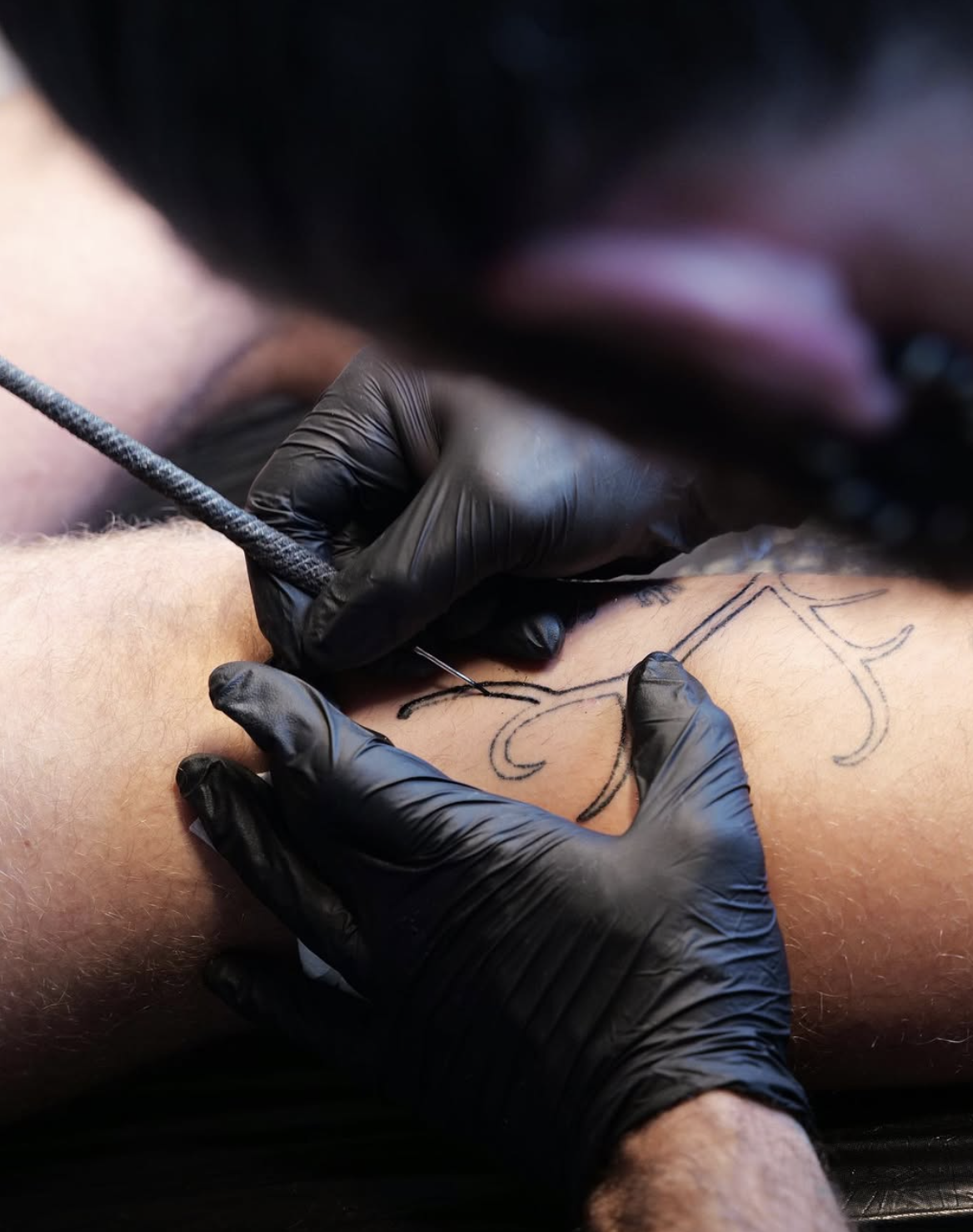 Close-up of a handpoke bindrune being tattooed